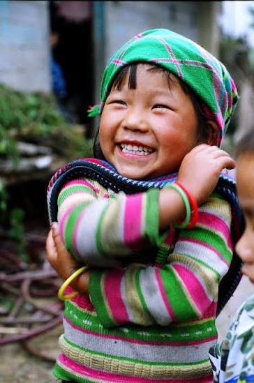 Bé gái đội khăn xanh cười tươi