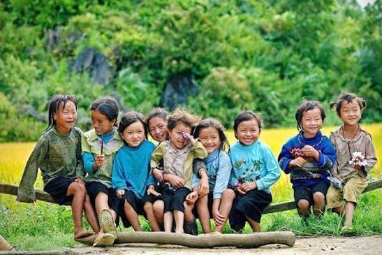 Nhóm đông trẻ em vùng cao ngồi cùng nhau trên khúc gỗ